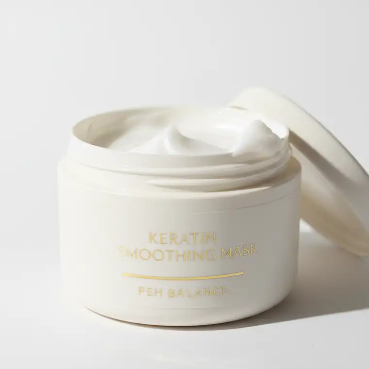 Kobieta nakłada maskę keratynową na włosy średnioporowate, dbając o równowagę PEH i brak przeproteinowania podczas pielęgnacji